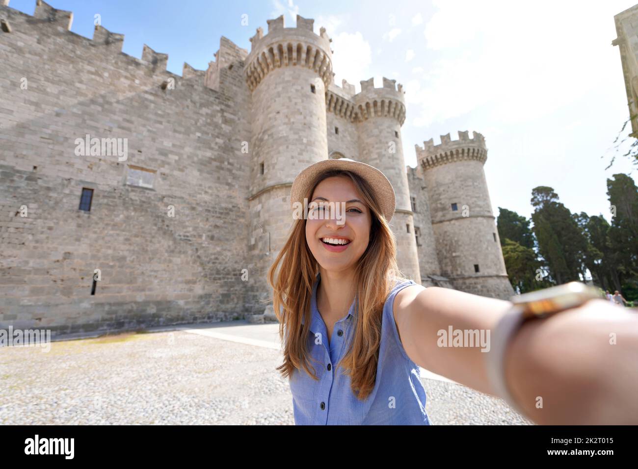 Young woman taking self portrait in front of Palace of the Grand Master of the Knights of Rhodes, Greece Stock Photo