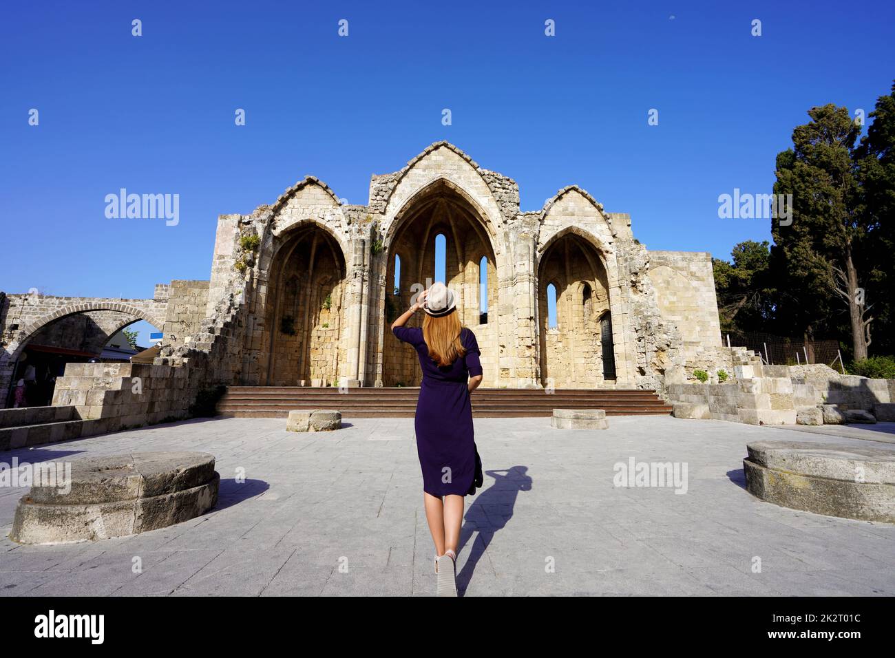 Back view of tourist girl visiting Church of the Virgin of the Burgh, Rhodes, Greece Stock Photo