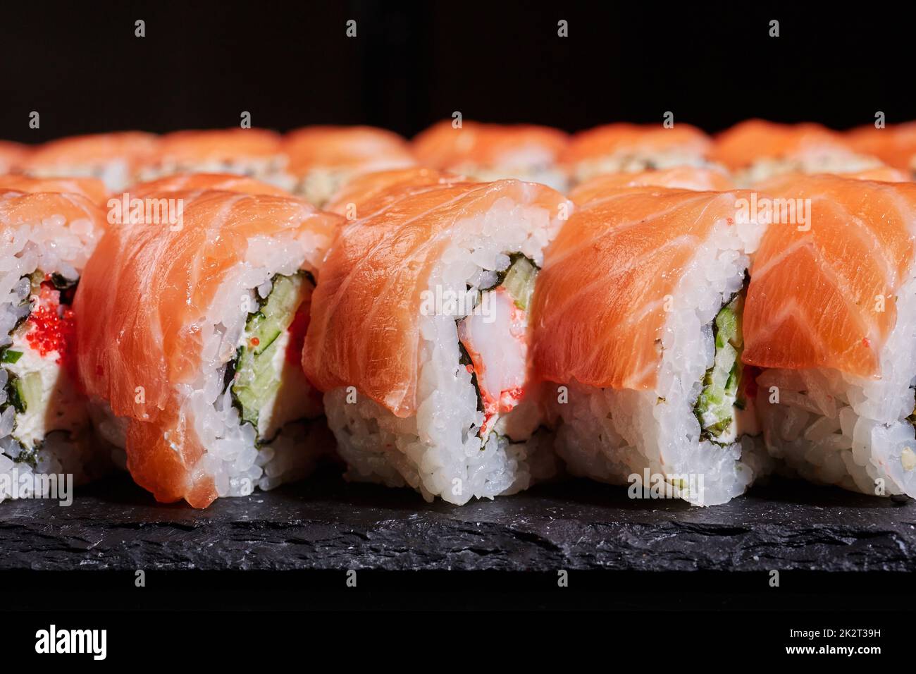 Chinese traditional dish. Close up side view of sliced Philadelphia sushi roll. Stock Photo