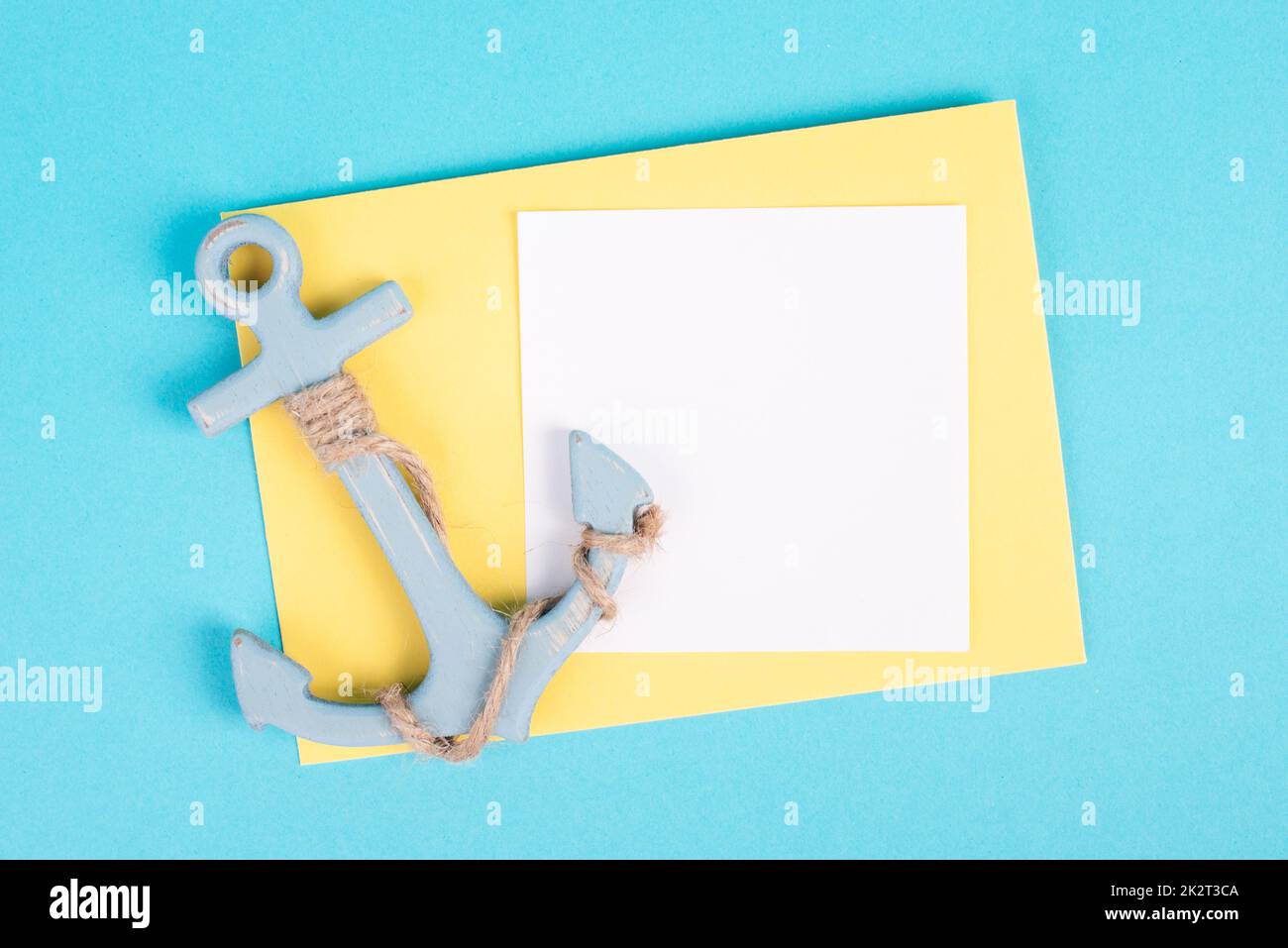 White anchor on a blue and yellow background, maritime sea life, sailing trip, summer vacation, tourism concept, copy space for text Stock Photo
