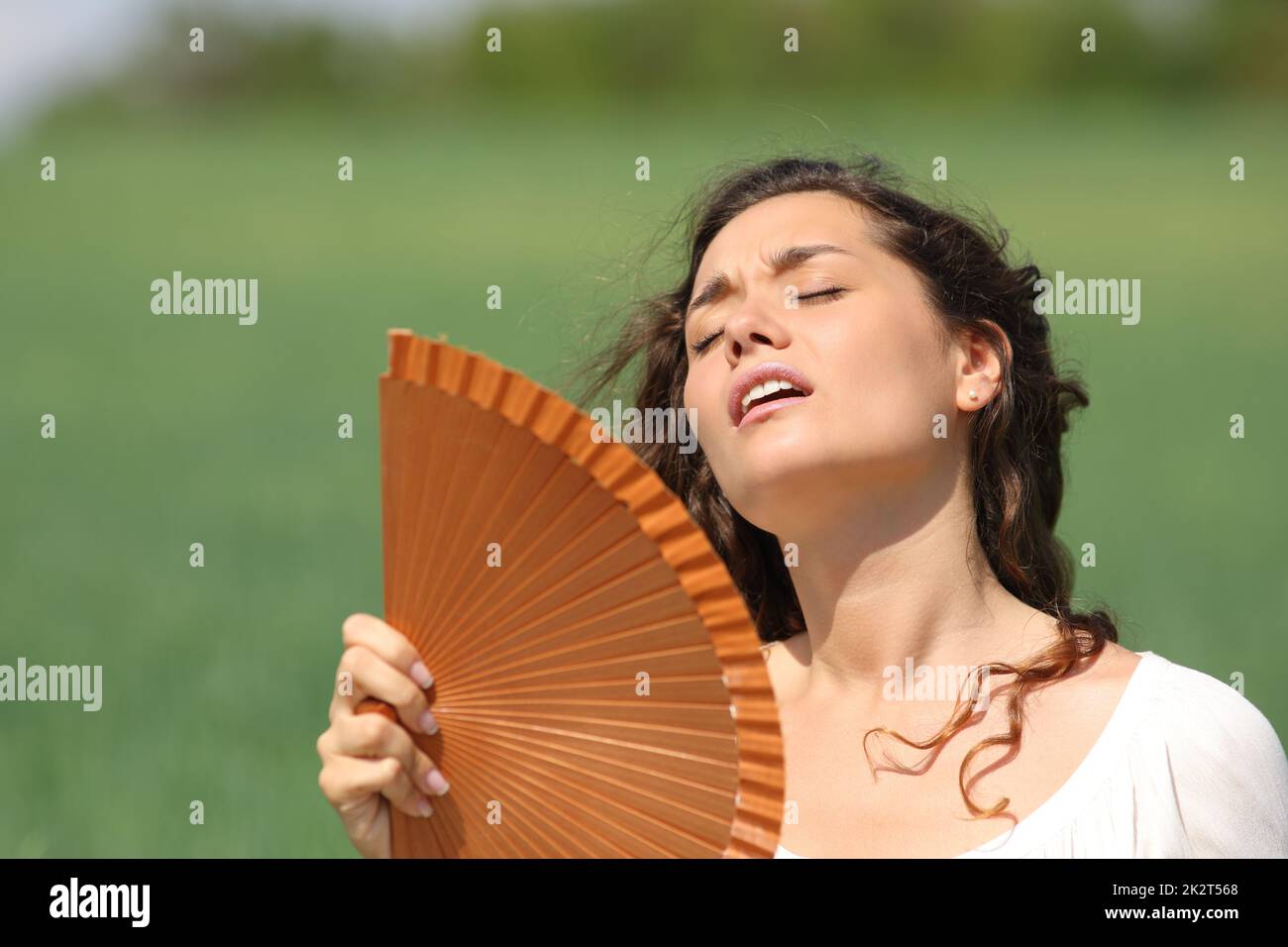 Stressed woman suffering heat stroke in a field Stock Photo