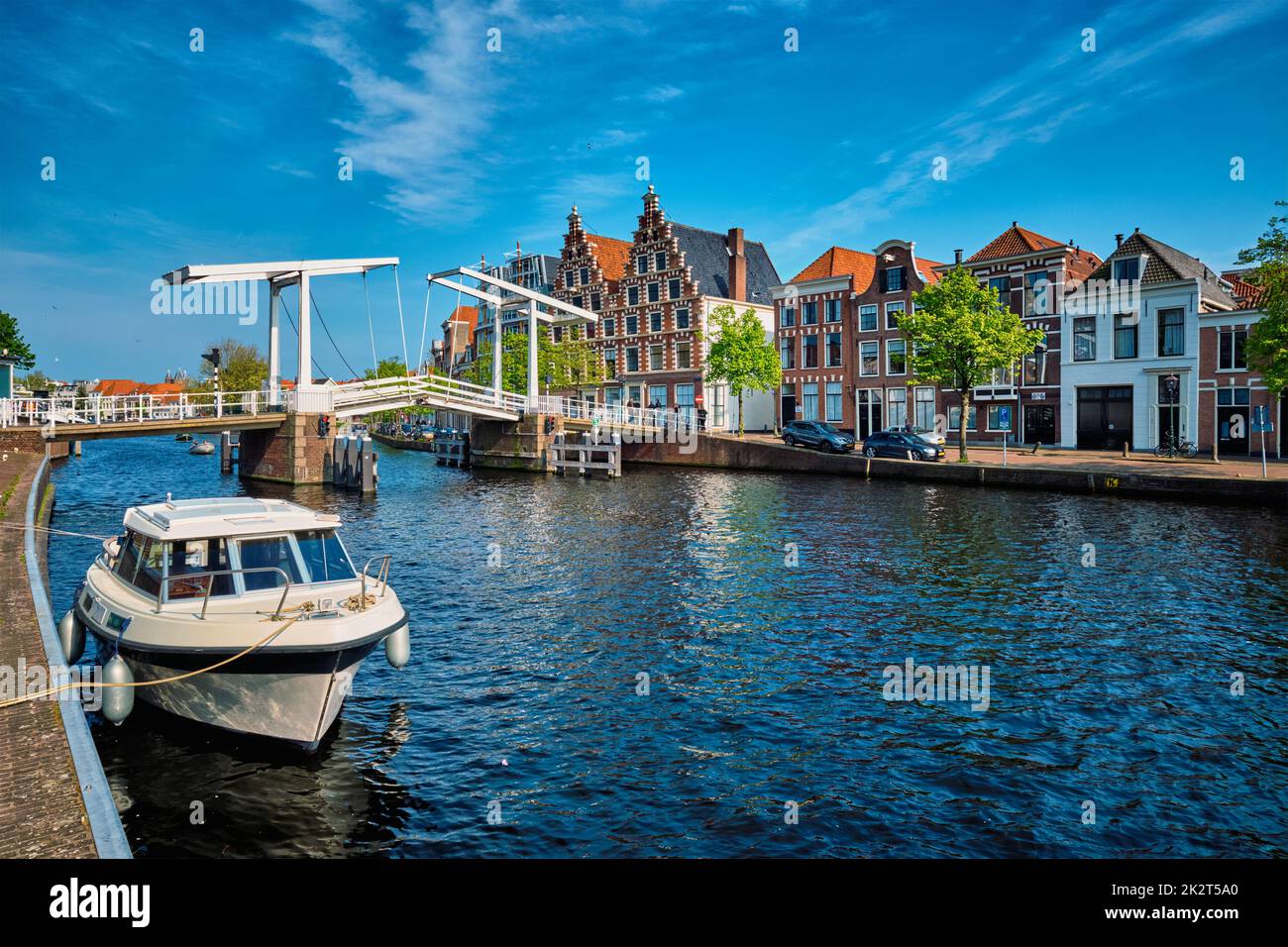 Spaarne river with boat and Gravestenenbrug bridge in Haarlem, N Stock Photo