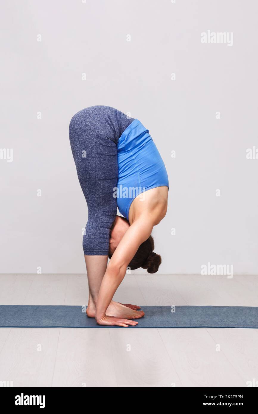 Woman doing yoga asana Uttanasana - standing forward bend Stock Photo