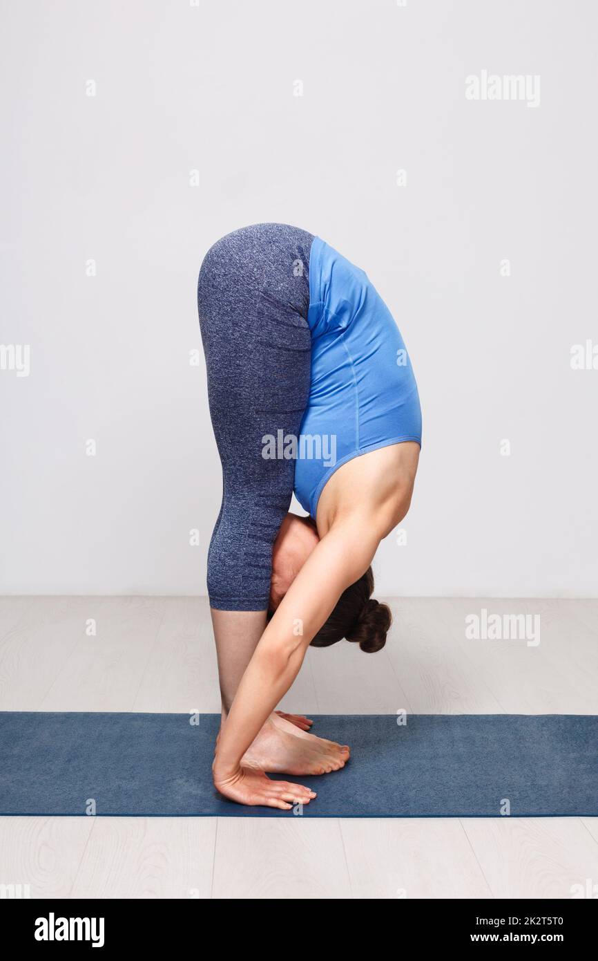 Woman doing yoga asana Uttanasana - standing forward bend Stock Photo