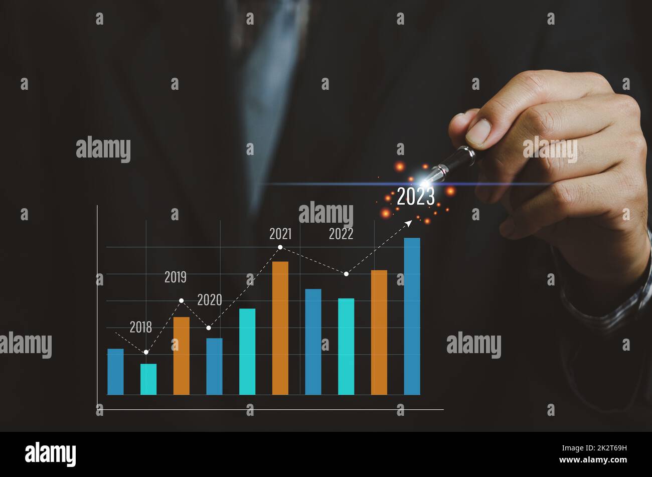 Analysis of business growth trends and company finances Businessman working with virtual screen graph and chart. arrow pointing to 2023 Stock Photo