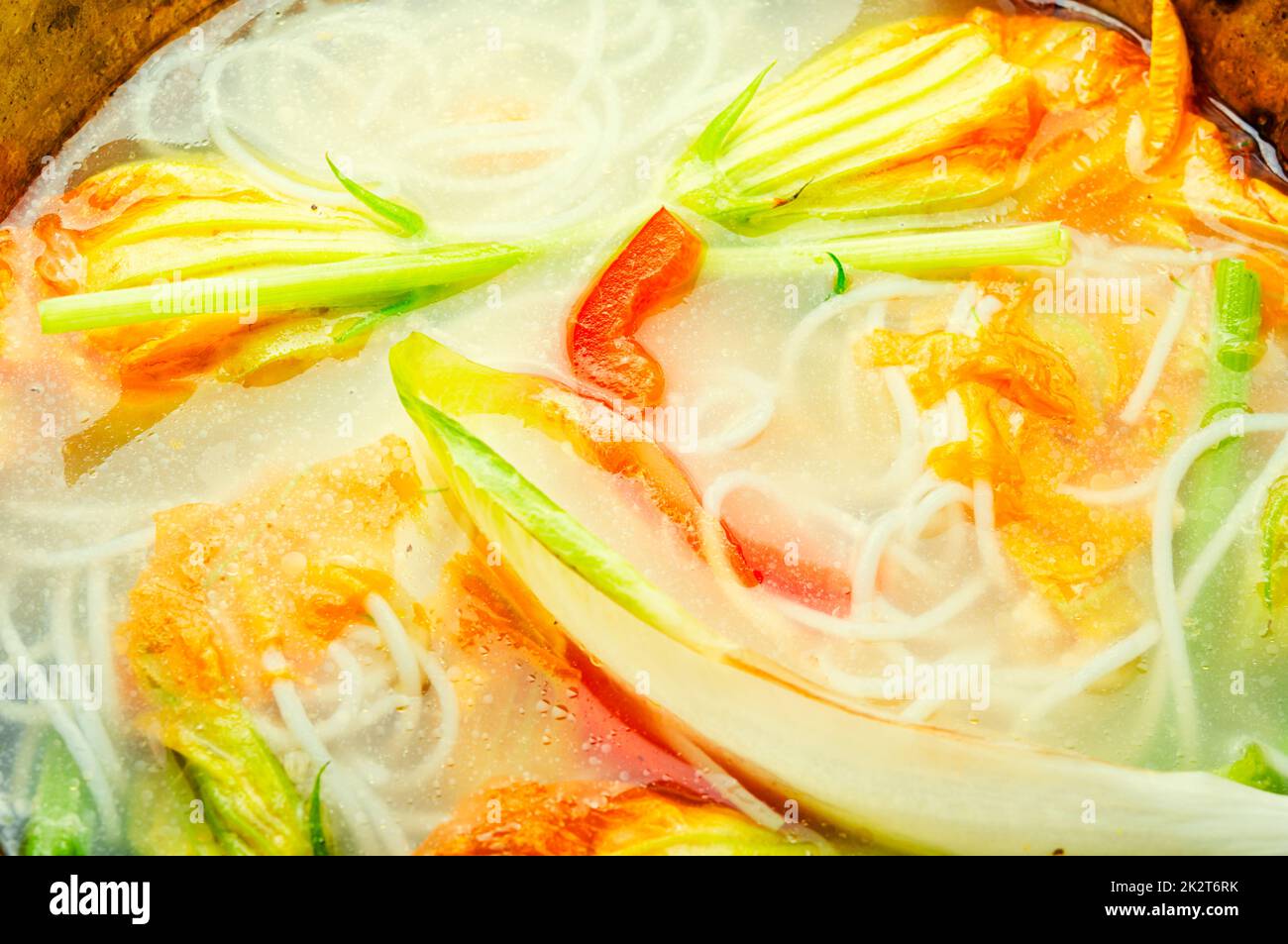 Vegan noodle soup with zucchini flowers Stock Photo Alamy