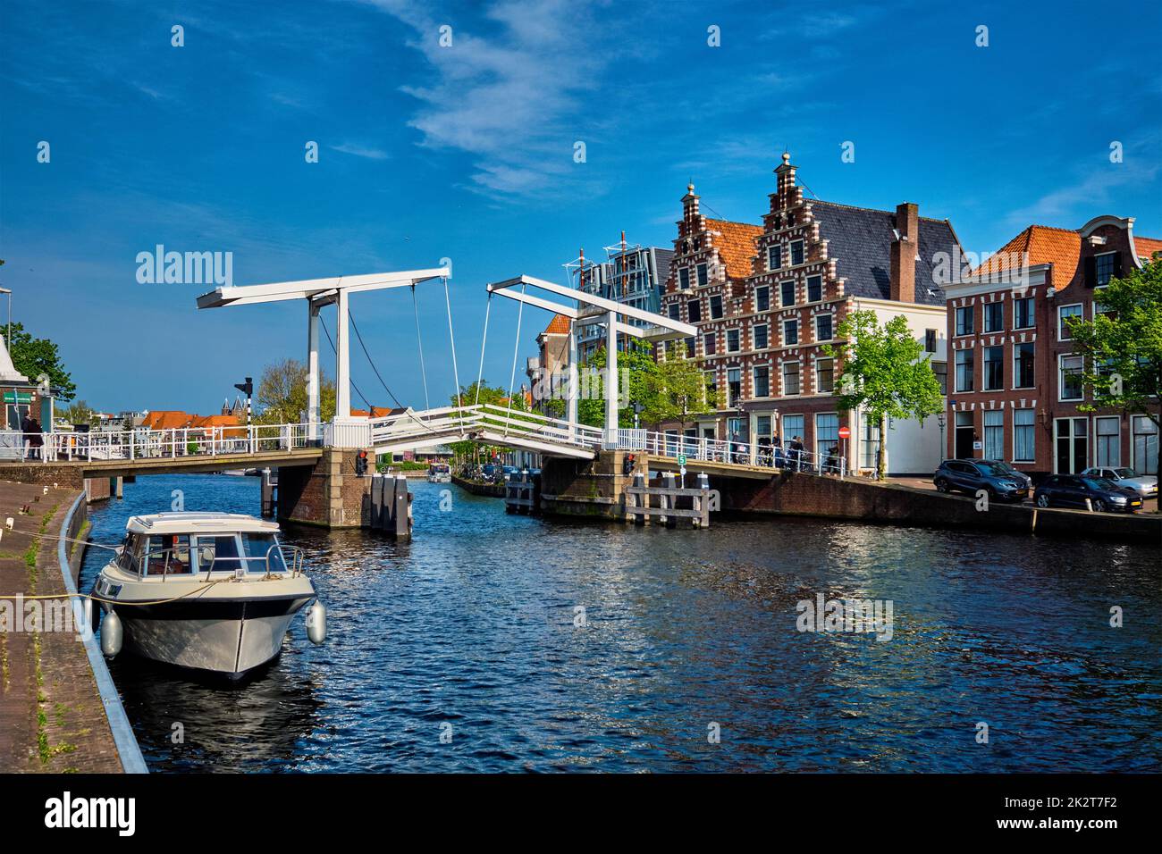 Spaarne river with boat and Gravestenenbrug bridge in Haarlem, N Stock Photo