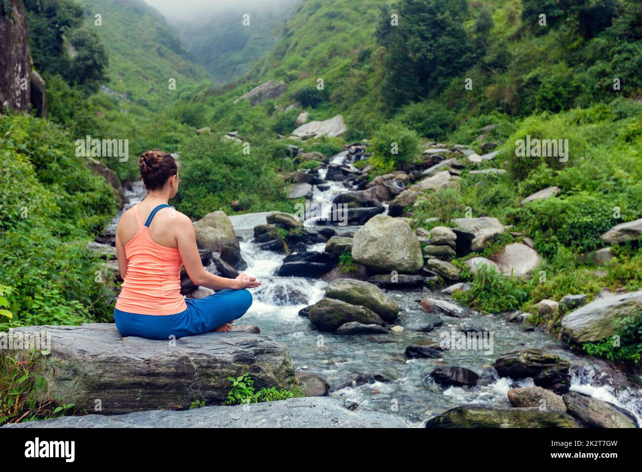 Woman doing yoga outdoors Stock Photo