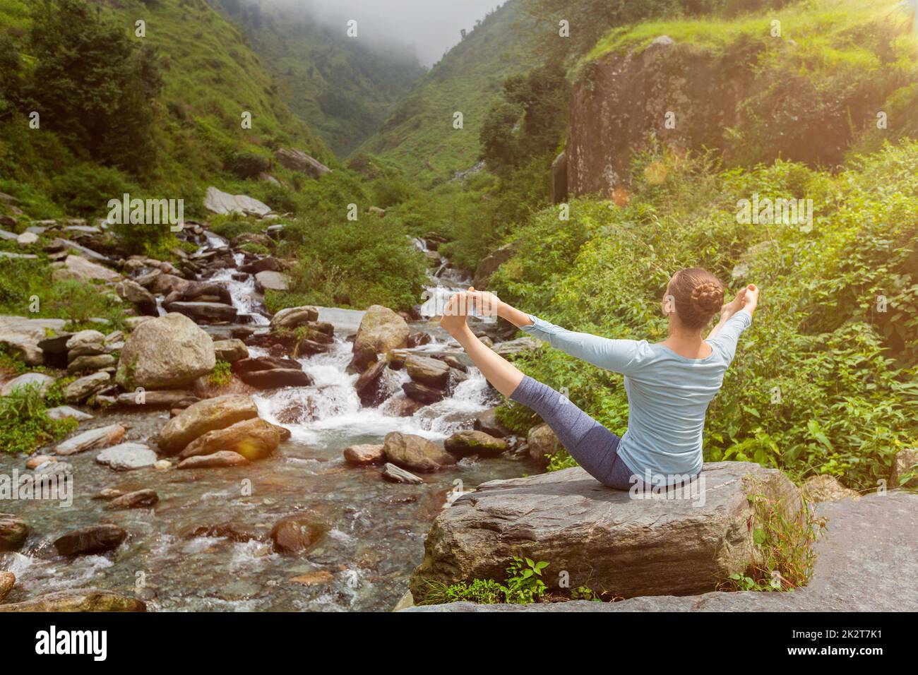 Woman doing Ashtanga Vinyasa Yoga asana outdoors Stock Photo