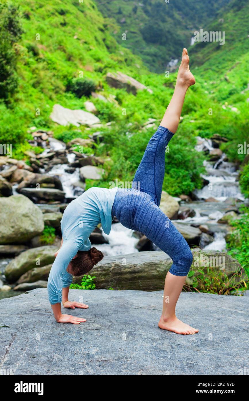 Woman doing yoga asana at waterfall Stock Photo