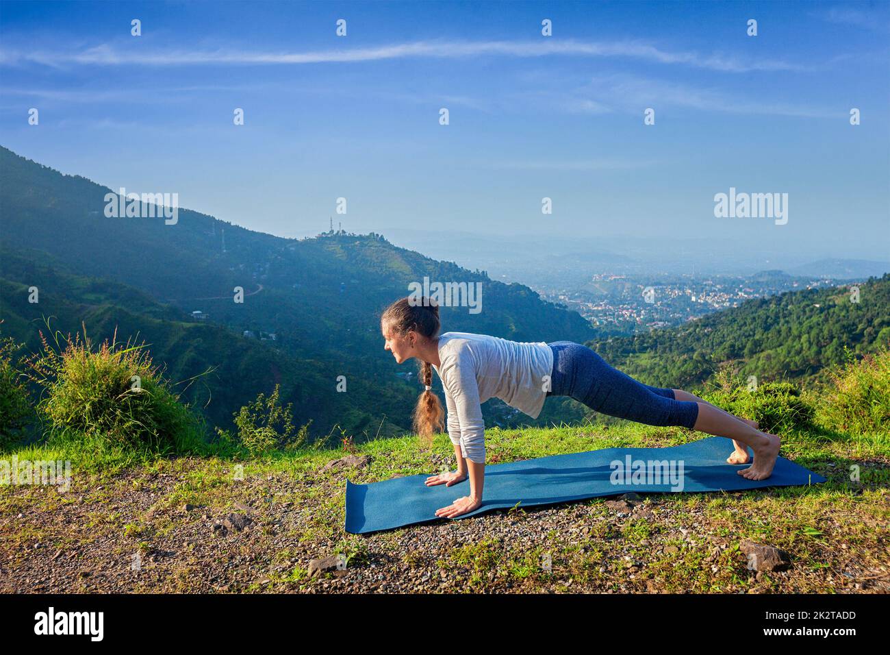 Woman doing Hatha yoga asana plank pose outdoors Stock Photo