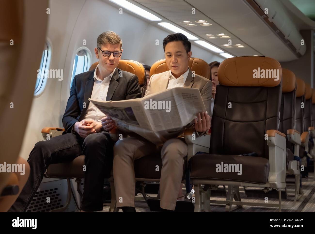 Businessman in brown suit on trip holding business newspaper while