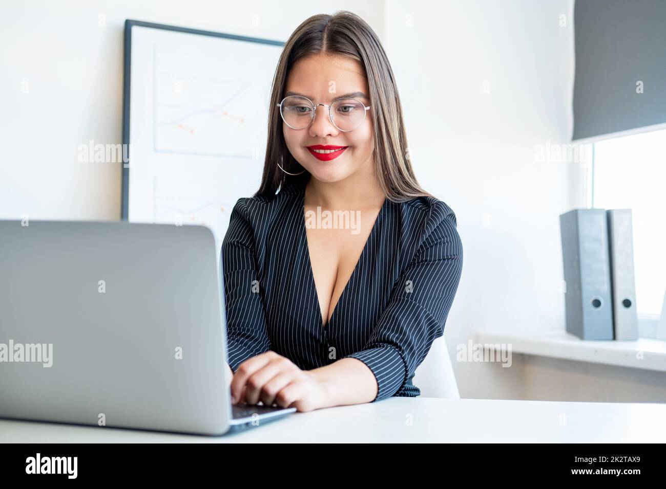 Business woman lifestyle. Successful career. Project management. Corporate chat. Cheerful confident smart lady in glasses working on project with lapt Stock Photo