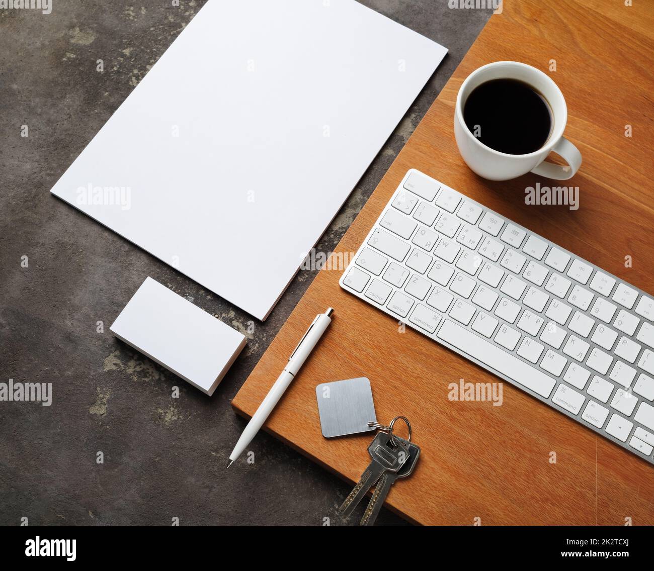 Blank stationery, keys, coffee cup and keyboard. Real estate agency concept. Stock Photo