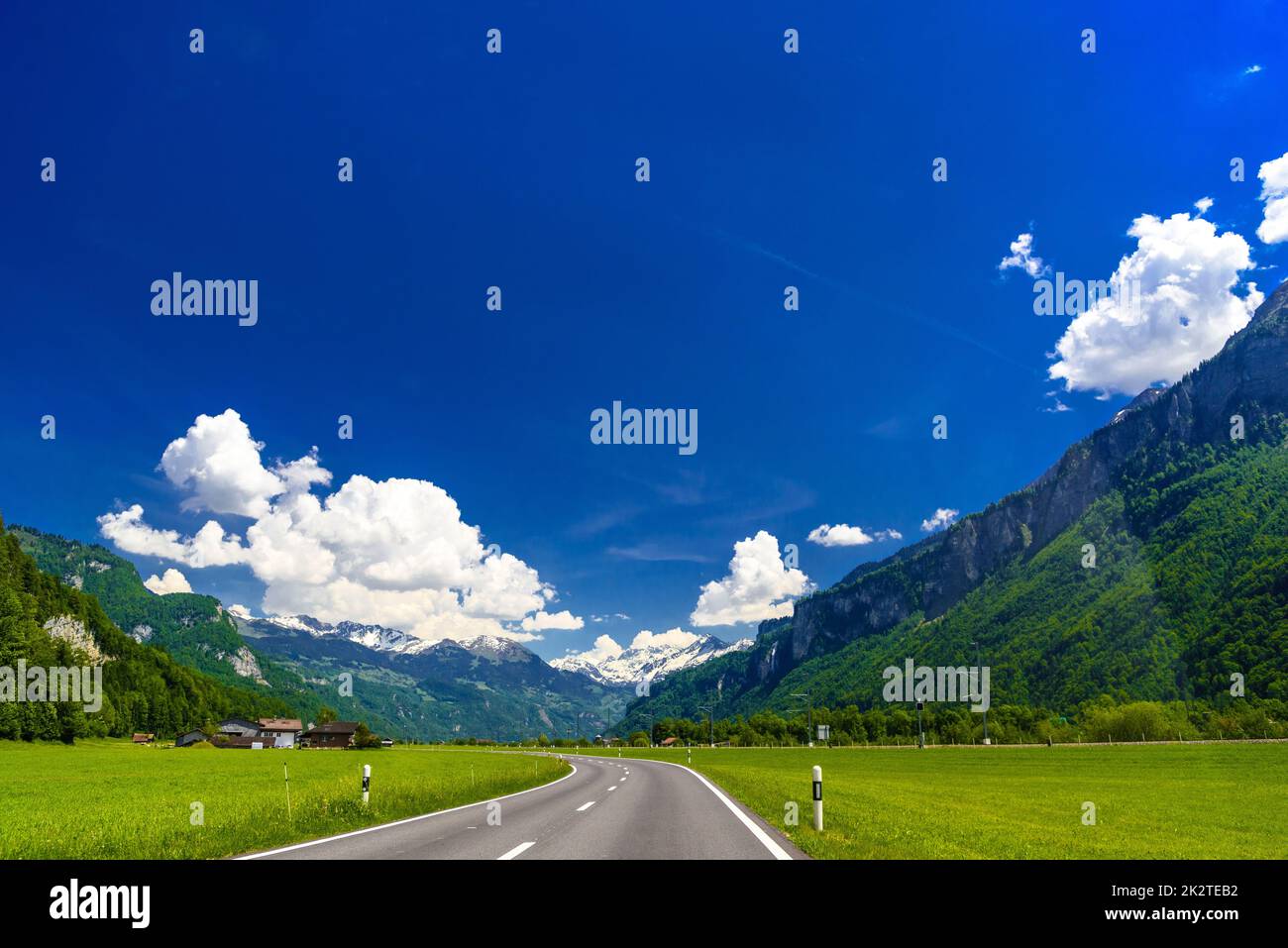 Asphalt road among green meadows, Brienz, InterlakenOberhasli Stock