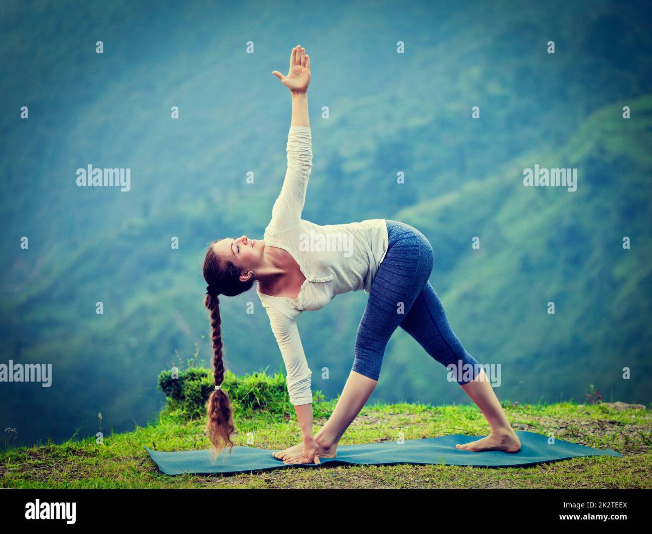 Woman doing Ashtanga Vinyasa yoga asana Parivrtta trikonasana Stock Photo