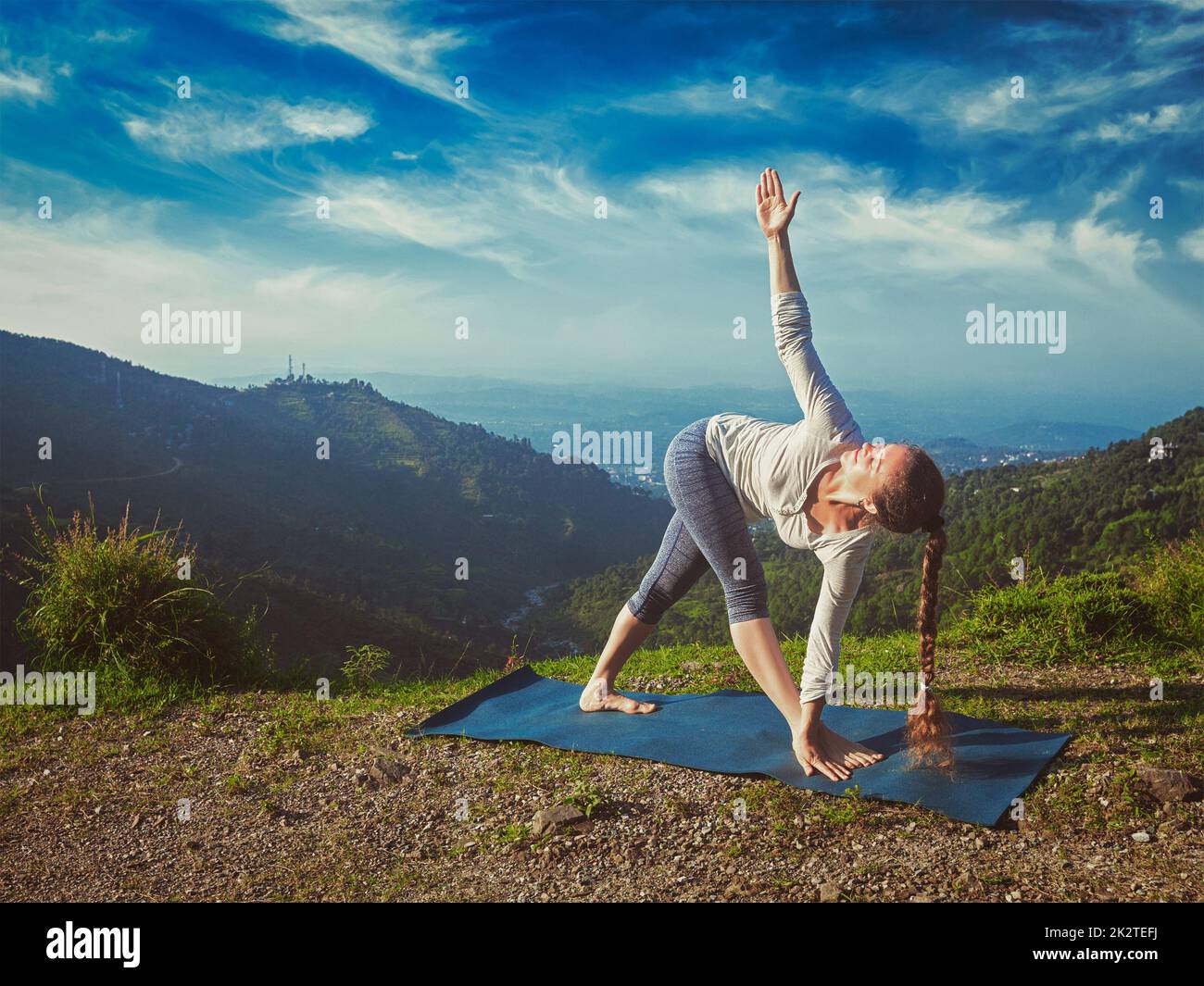 Woman doing Ashtanga Vinyasa yoga asana Parivrtta trikonasana Stock Photo