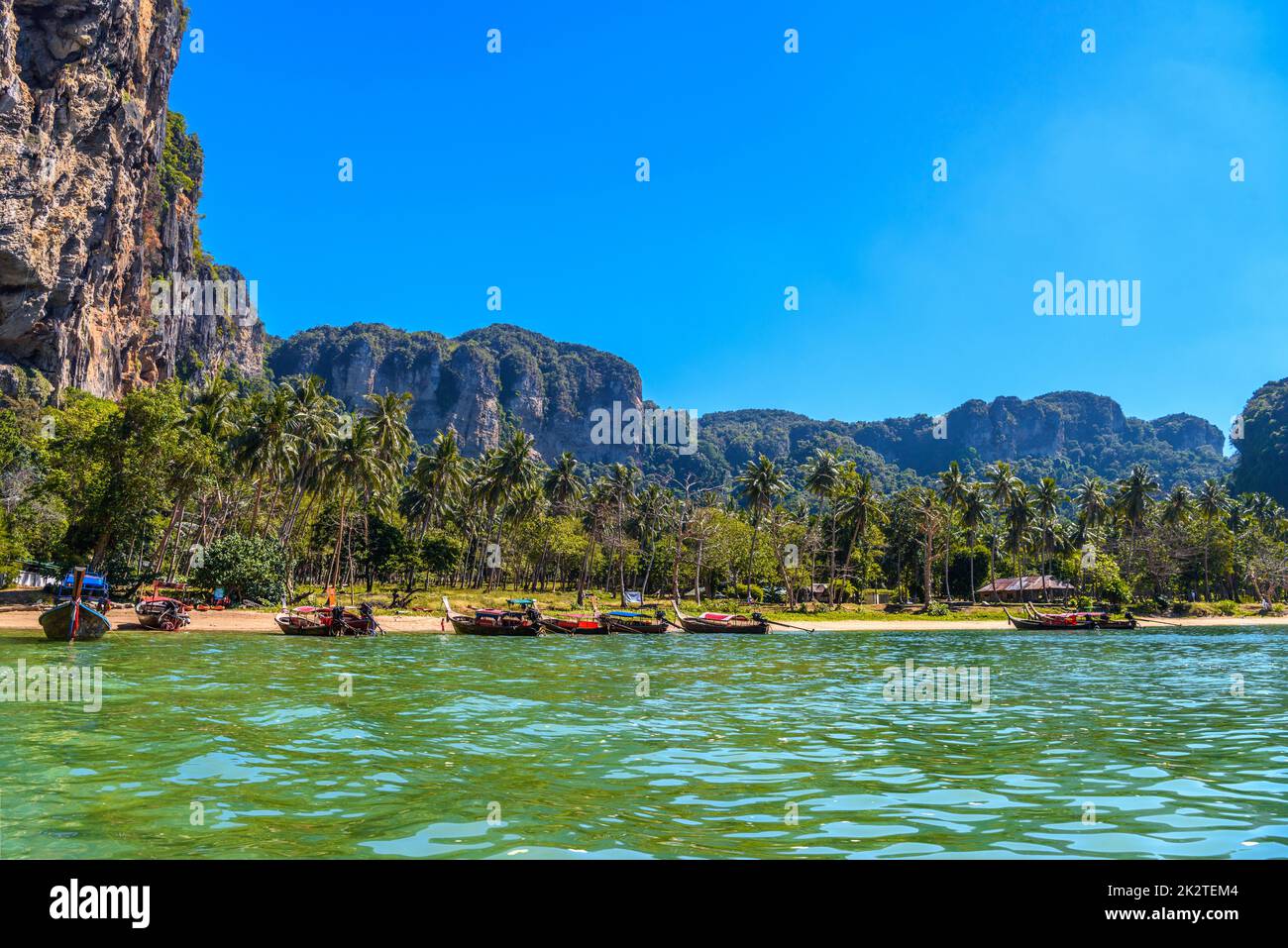 Long tail boats on tropical beach with palms, Tonsai Bay, Railay Stock Photo