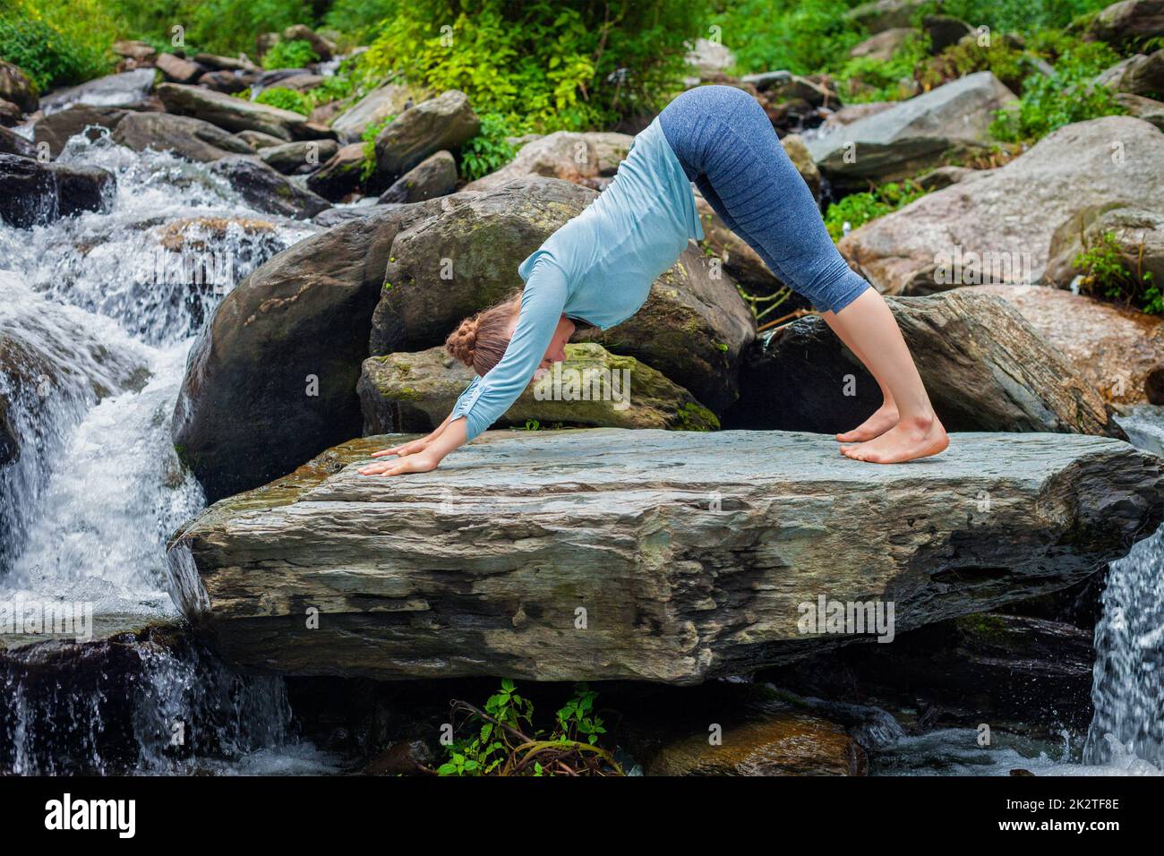 Young sporty fit woman doing yoga oudoors at tropical waterfall Stock ...
