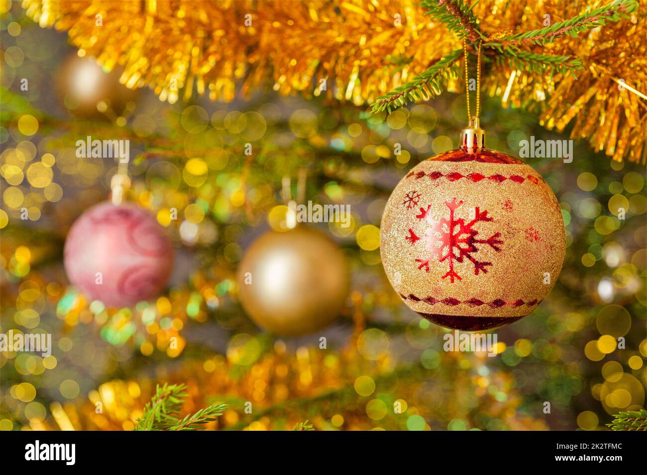 Decoration bauble on decorated Christmas tree background Stock Photo