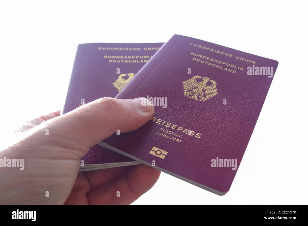 A male hand holds two German passports for passport control Stock Photo