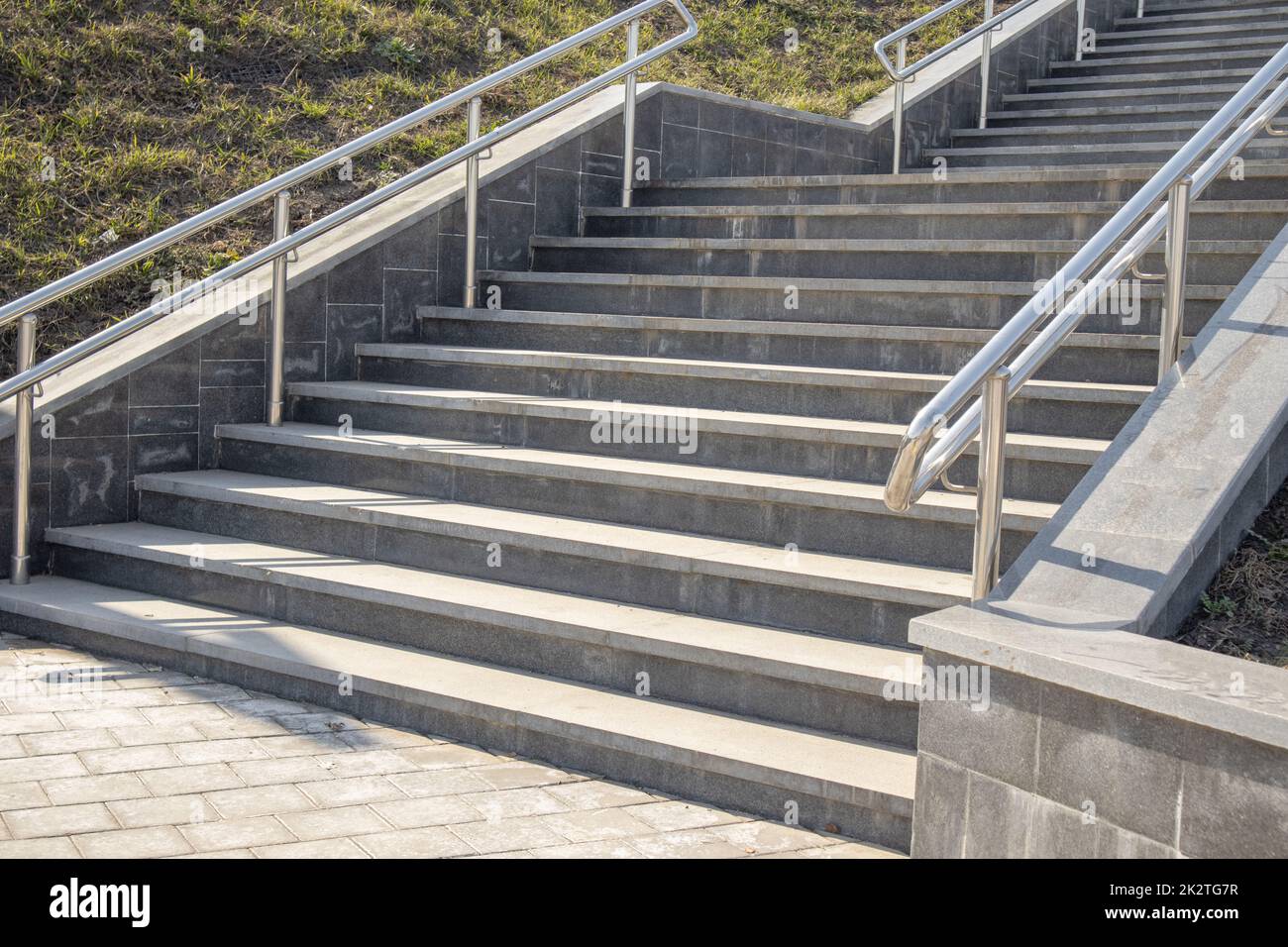 Outdoor concrete steps on a modern city staircase with metal railings on a sunny day, outdoors, bottom view Stock Photo