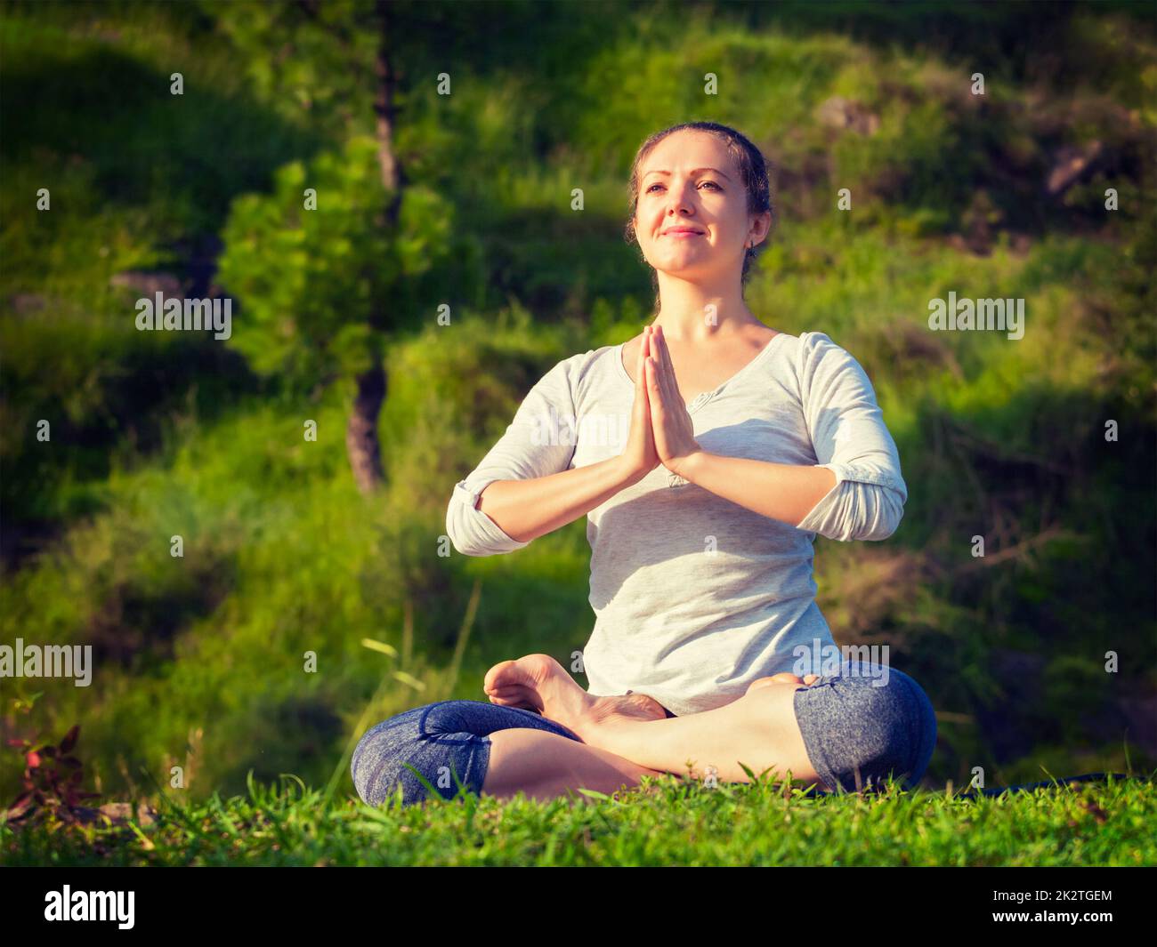 Young sporty fit woman doing yoga Lotus pose oudoors Stock Photo - Alamy