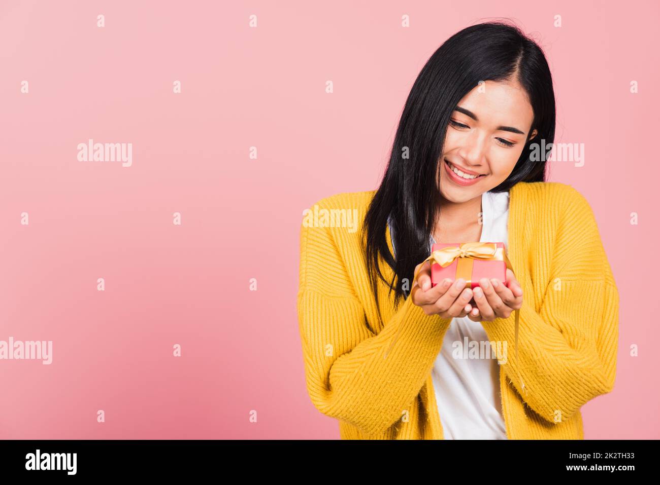 woman smiling holding small gift box on hands Stock Photo