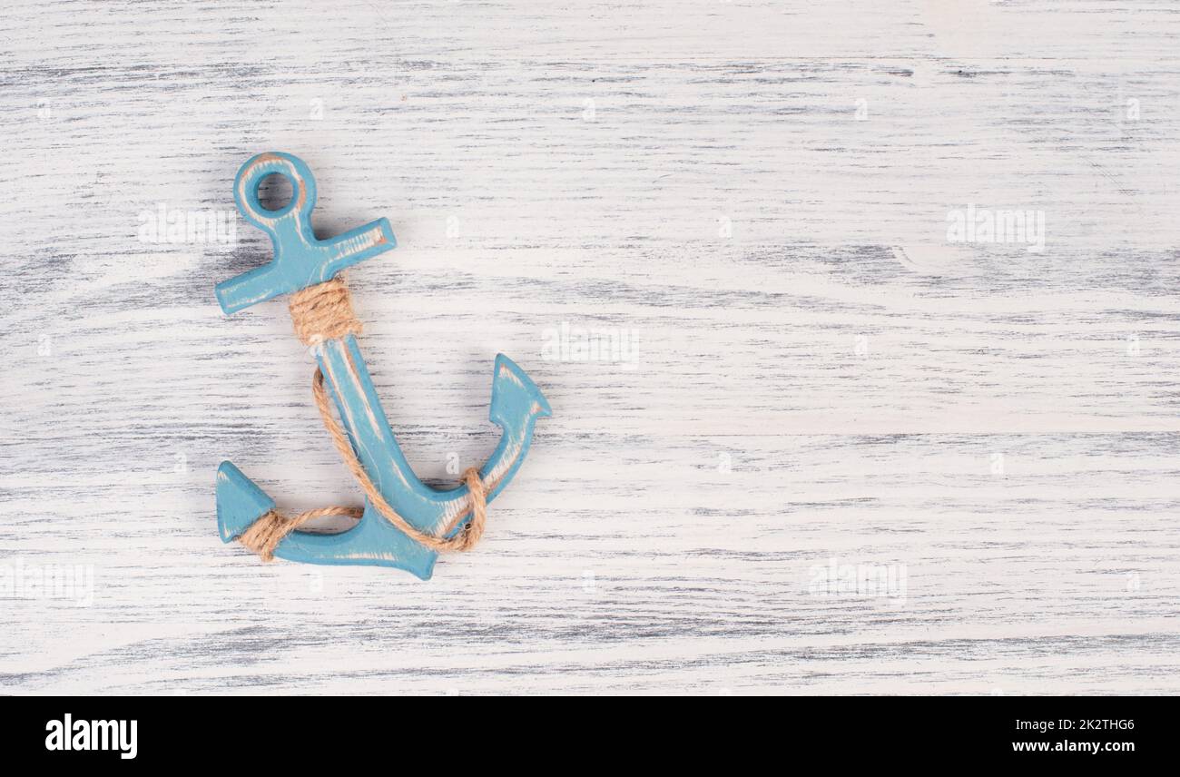 Blue anchor on a white textured background, maritime sea life, sailing trip, summer vacation, tourism concept, harbor Stock Photo