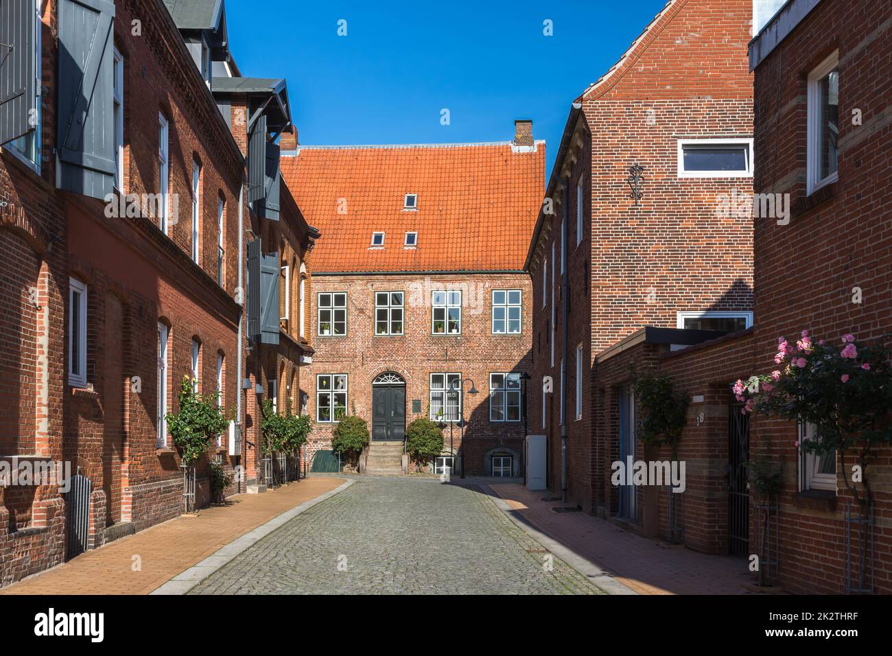 Public street with red brick buildings in Husum, North Frisia, Schleswig-Holstein, Germany Stock Photo