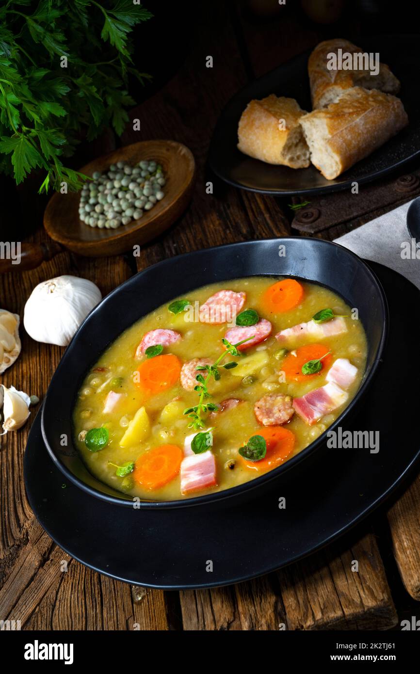 Hearty rustic pea soup with bacon and sausage Stock Photo