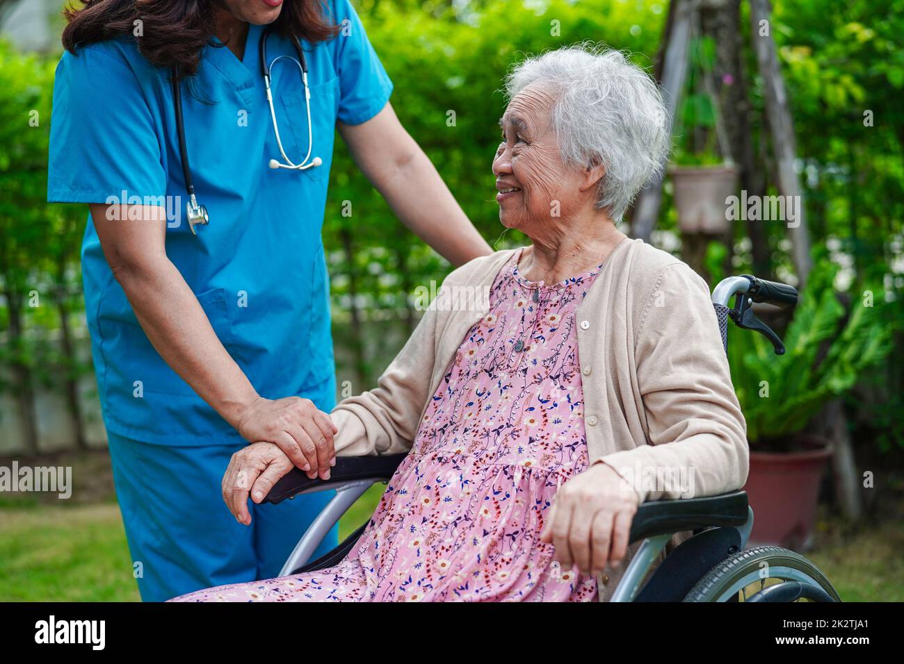Doctor help Asian elderly woman disability patient sitting on