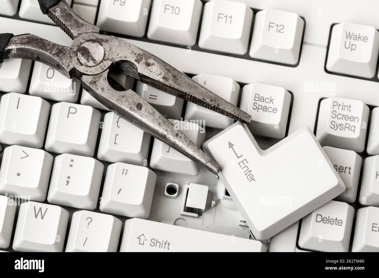 Pliers with ENTER key laying on the keyboard Stock Photo