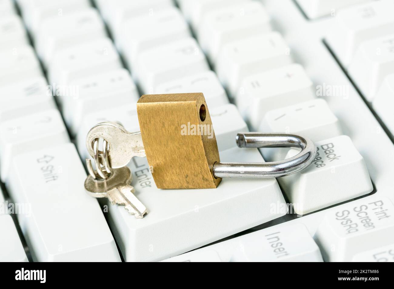 An unlocked padlock on top a computer keyboard Stock Photo