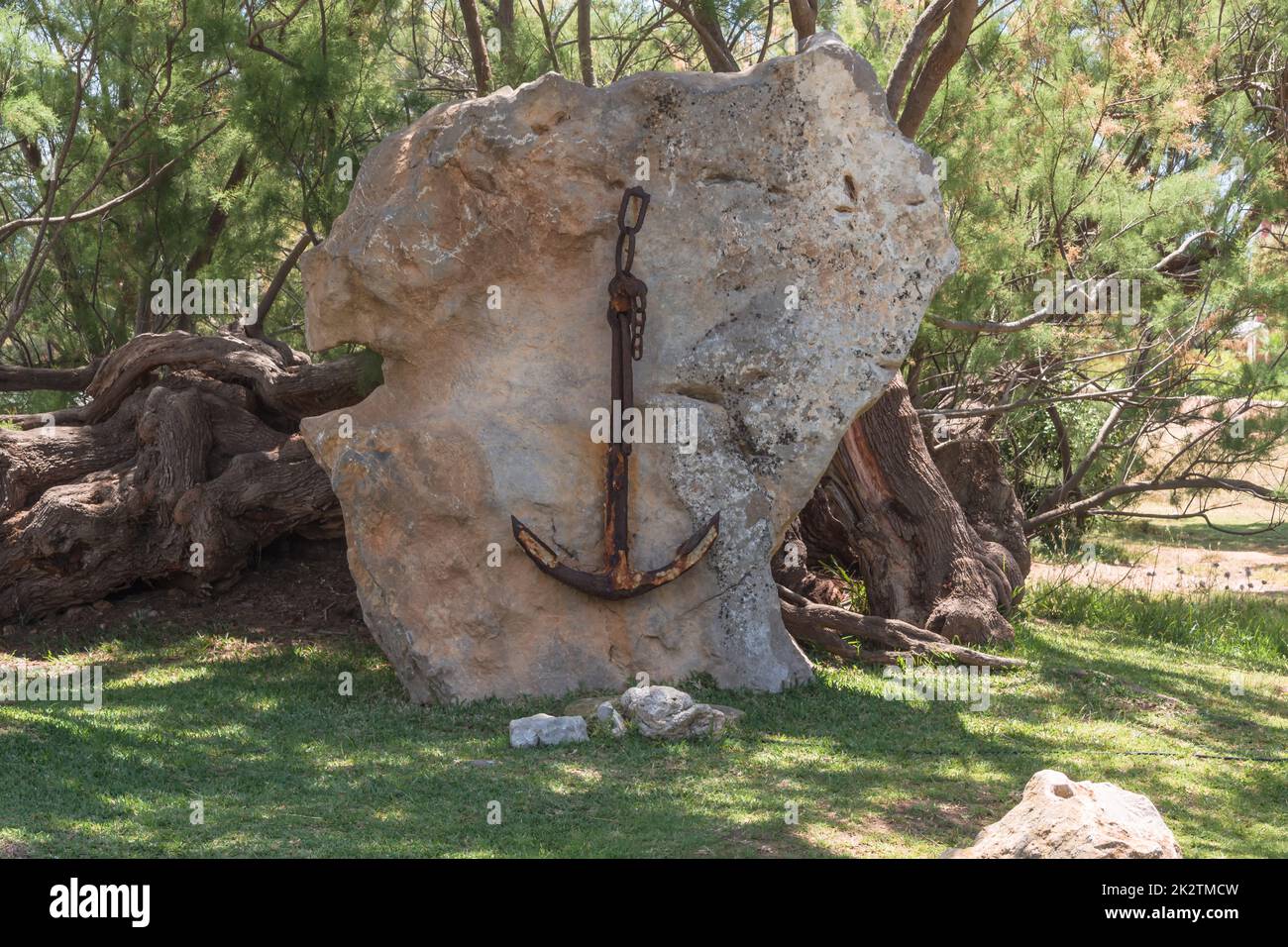 Old rusted ship anchor hanging on a stone in Majorca, Spain. Stock Photo