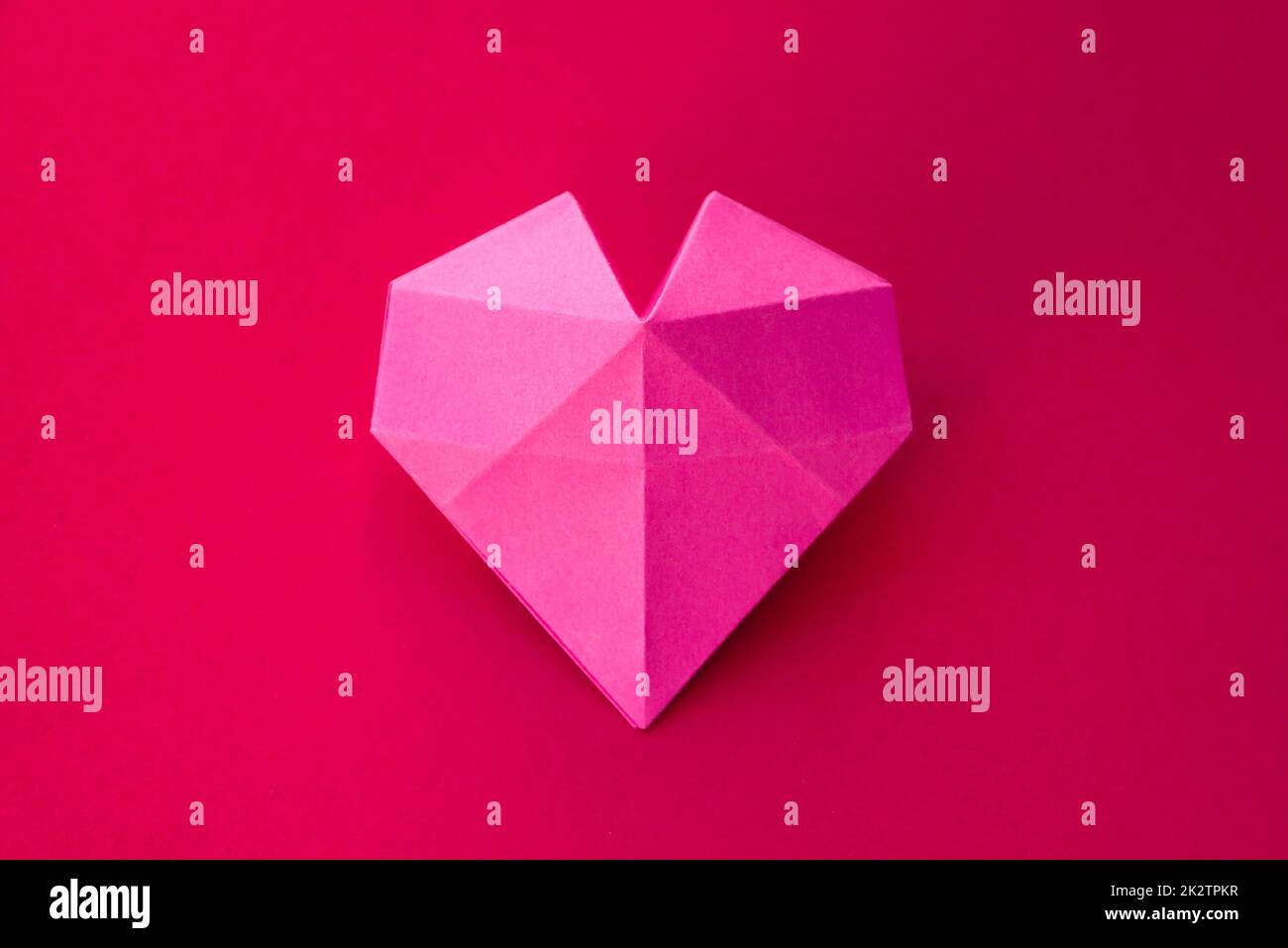 Pink paper heart origami isolated on a red background Stock Photo - Alamy