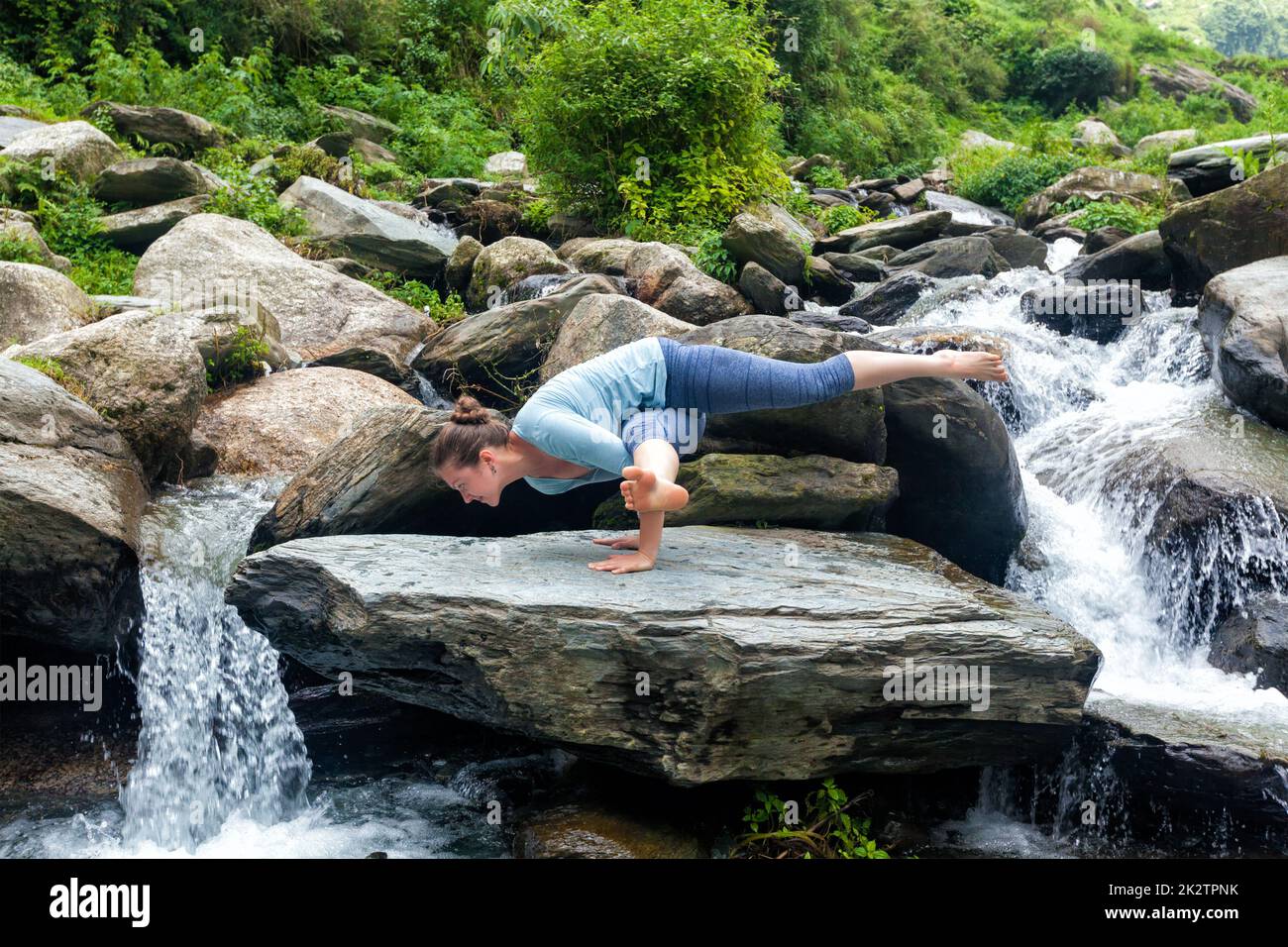 Young fit woman doing yoga oudoors at waterfall Stock Photo - Alamy