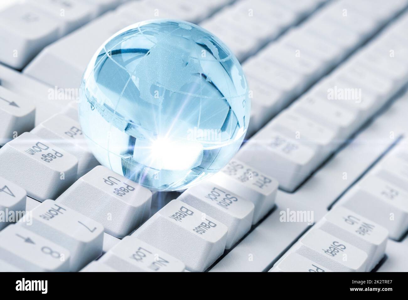 Crystal Earth globe on computer keyboard Stock Photo