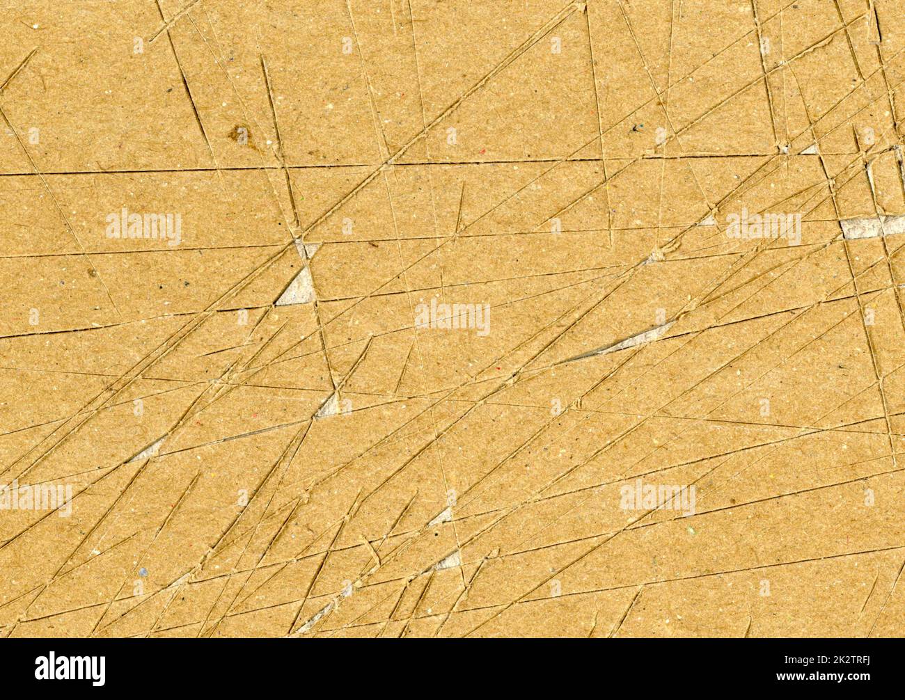 Small: Highly detailed close up brown paper board texture with many knife cut marks and scratches worn down, used grunge fine grain layered cardboard with torn surface for wallpaper design Stock Photo