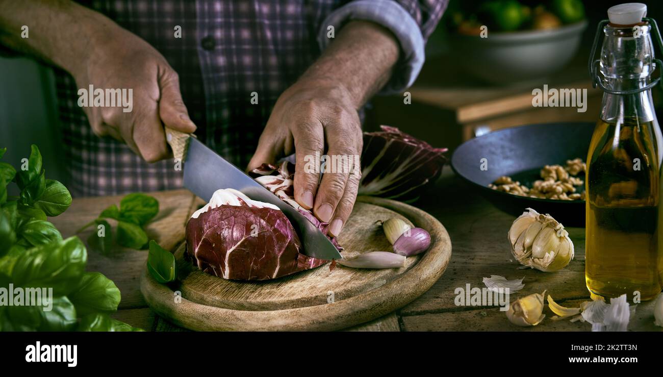 Crop male cutting cabbage on table Stock Photo