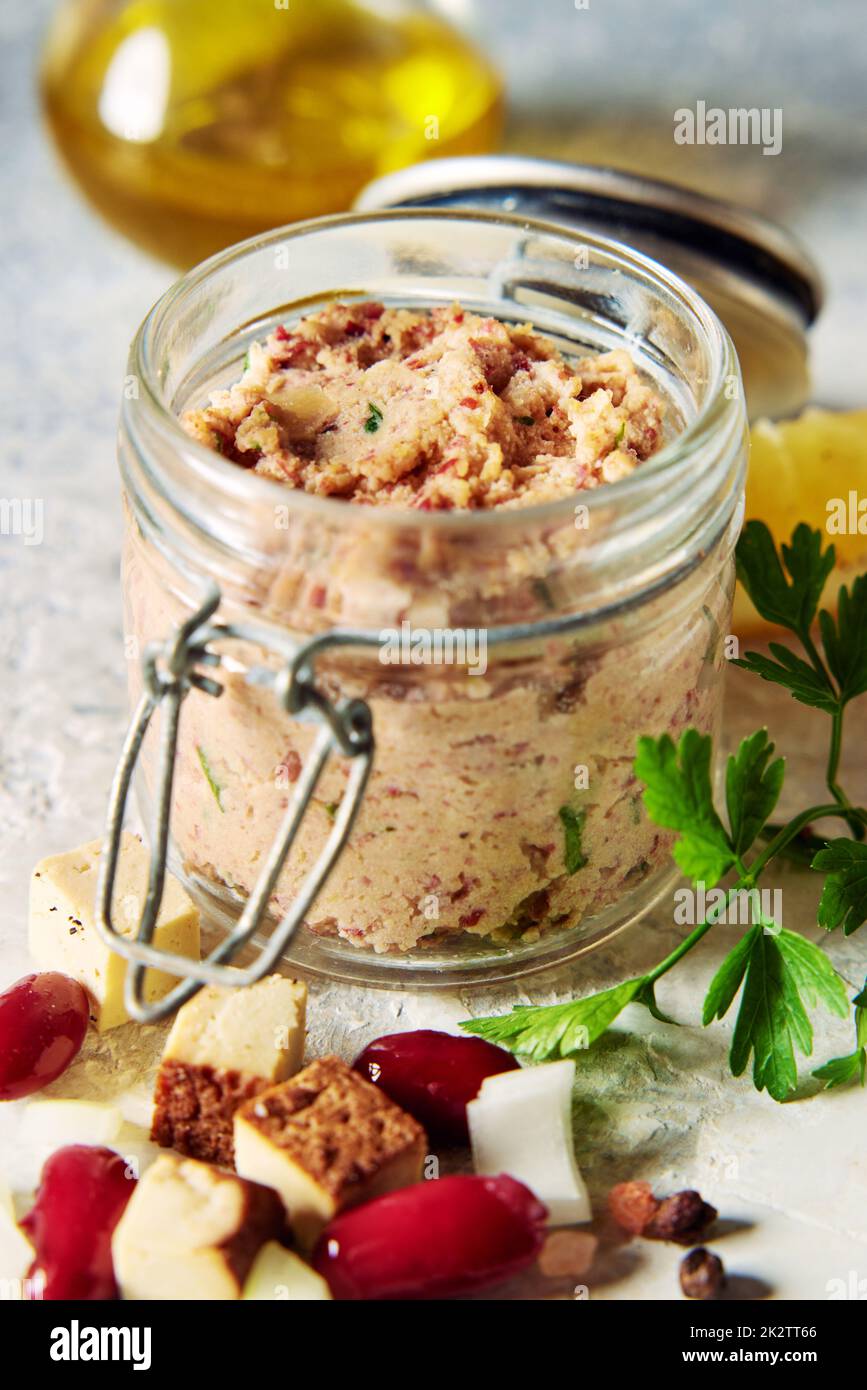 Jar of yummy vegan liverwurst pate served on table with cheese and