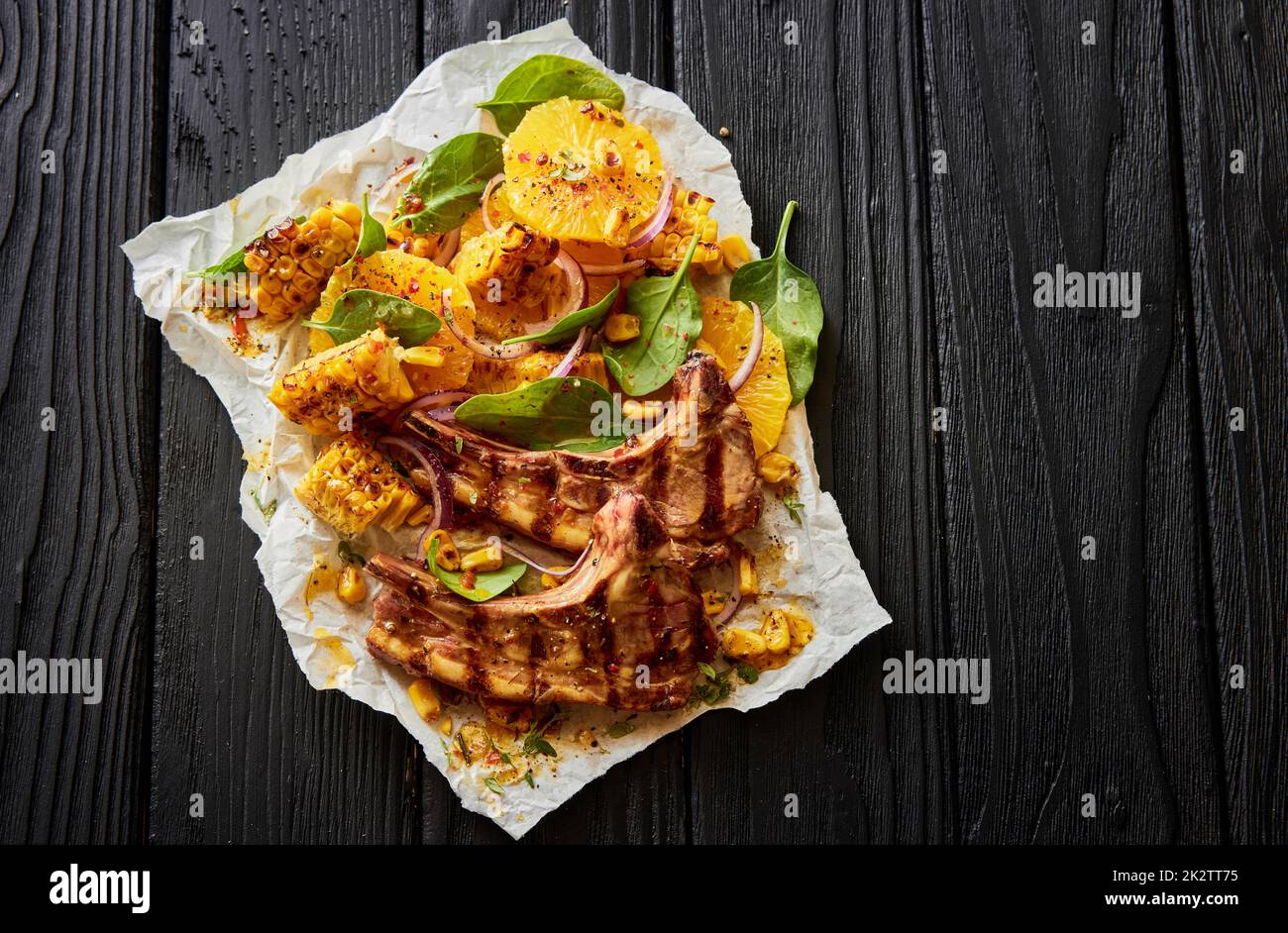 Lamb chops with corn on black table Stock Photo