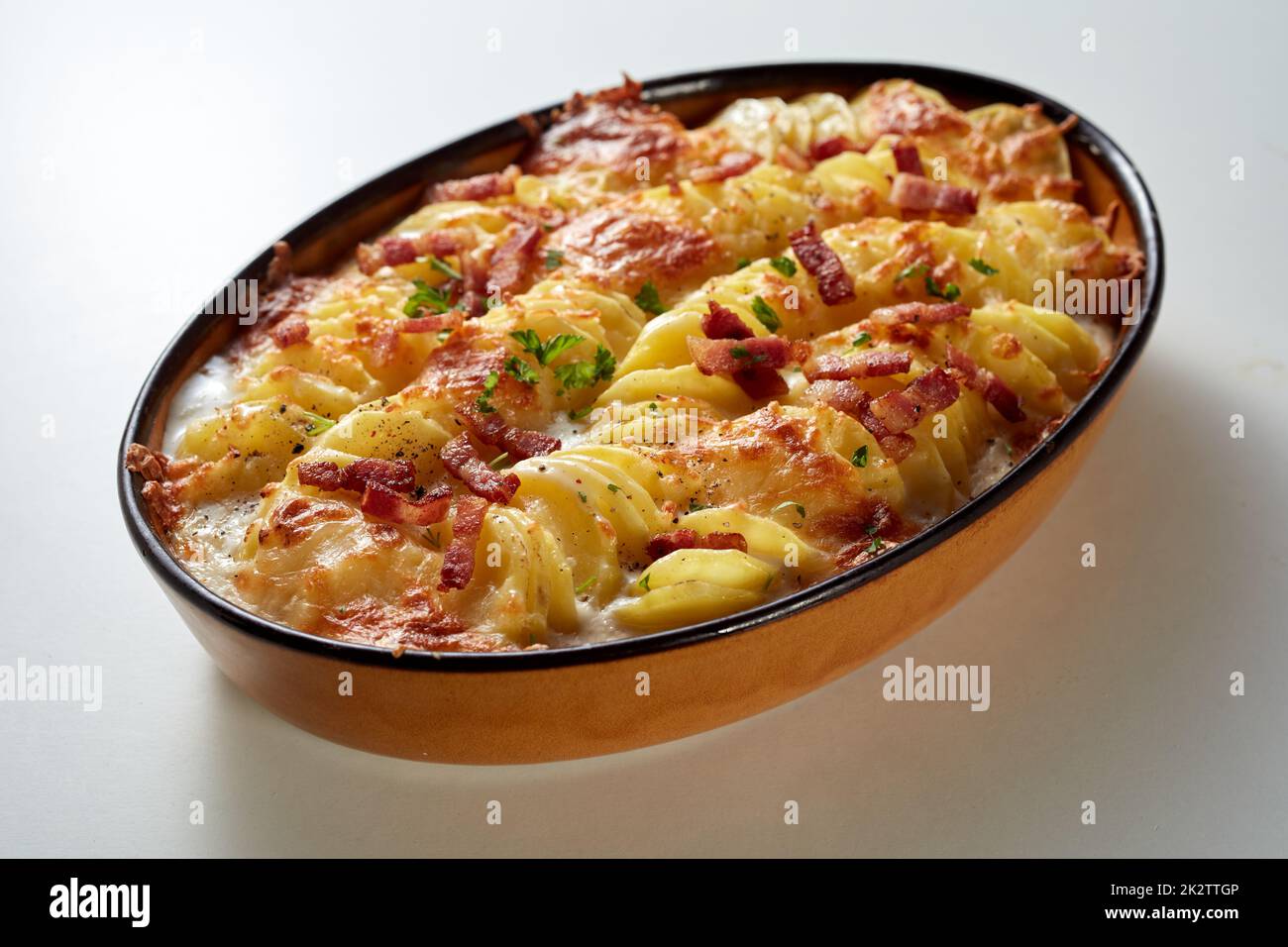 Oval pan with potato casserole with cheese and bacon Stock Photo
