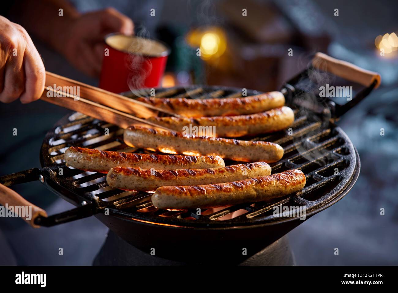 Man taking grilled sausage from barbecue Stock Photo Alamy