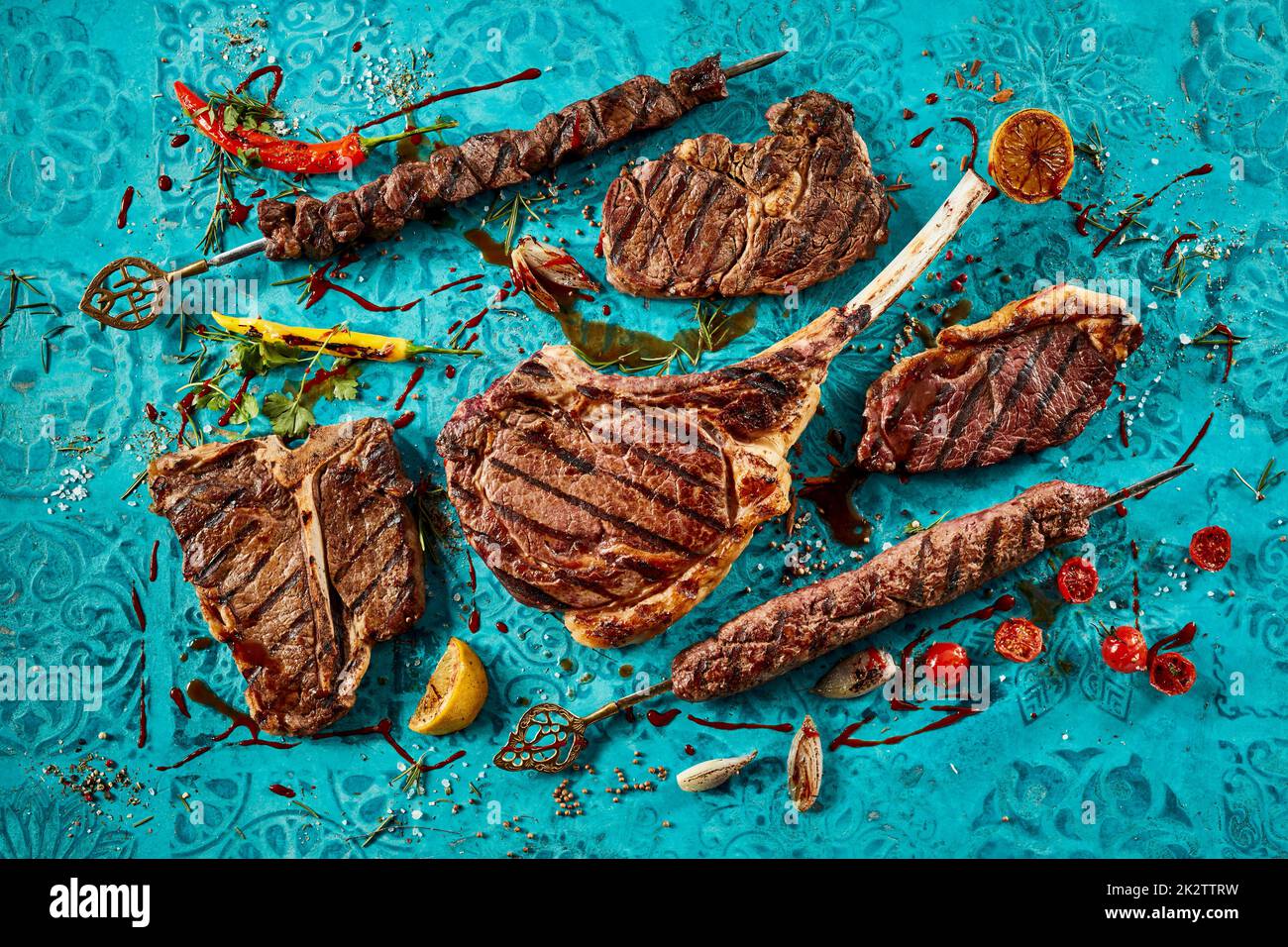 Grilled meat steaks placed on blue table Stock Photo