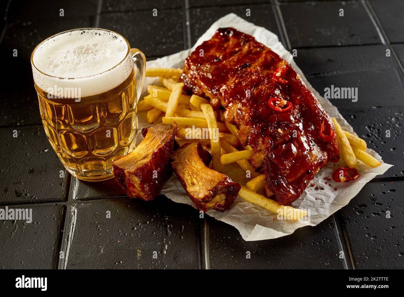 Beer and tasty fast food placed on table Stock Photo
