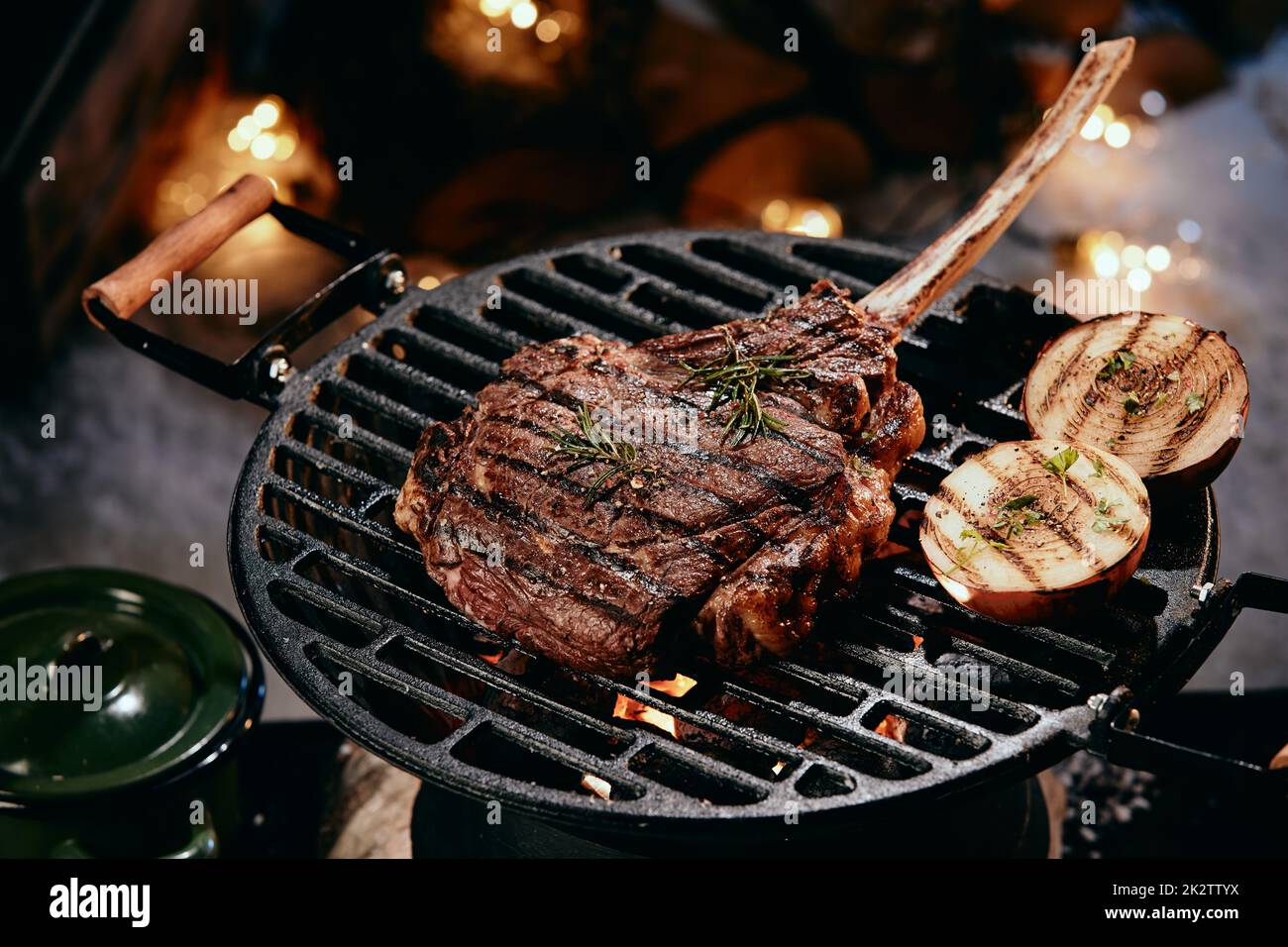 Tomahawk steak cooking on grill rack Stock Photo