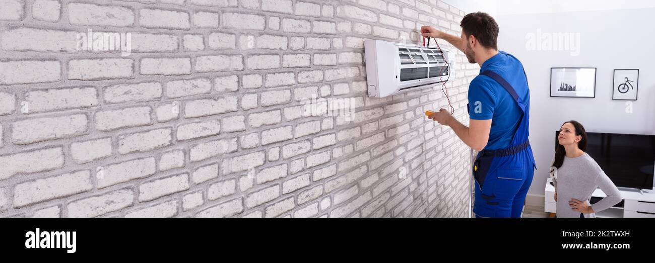 Technician Repairing Air Conditioner With Digital Multimeter Stock Photo