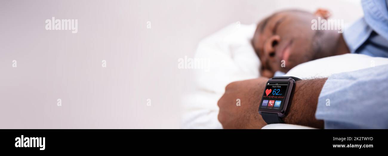 Man Sleeping With Smart Watch In His Hand Stock Photo