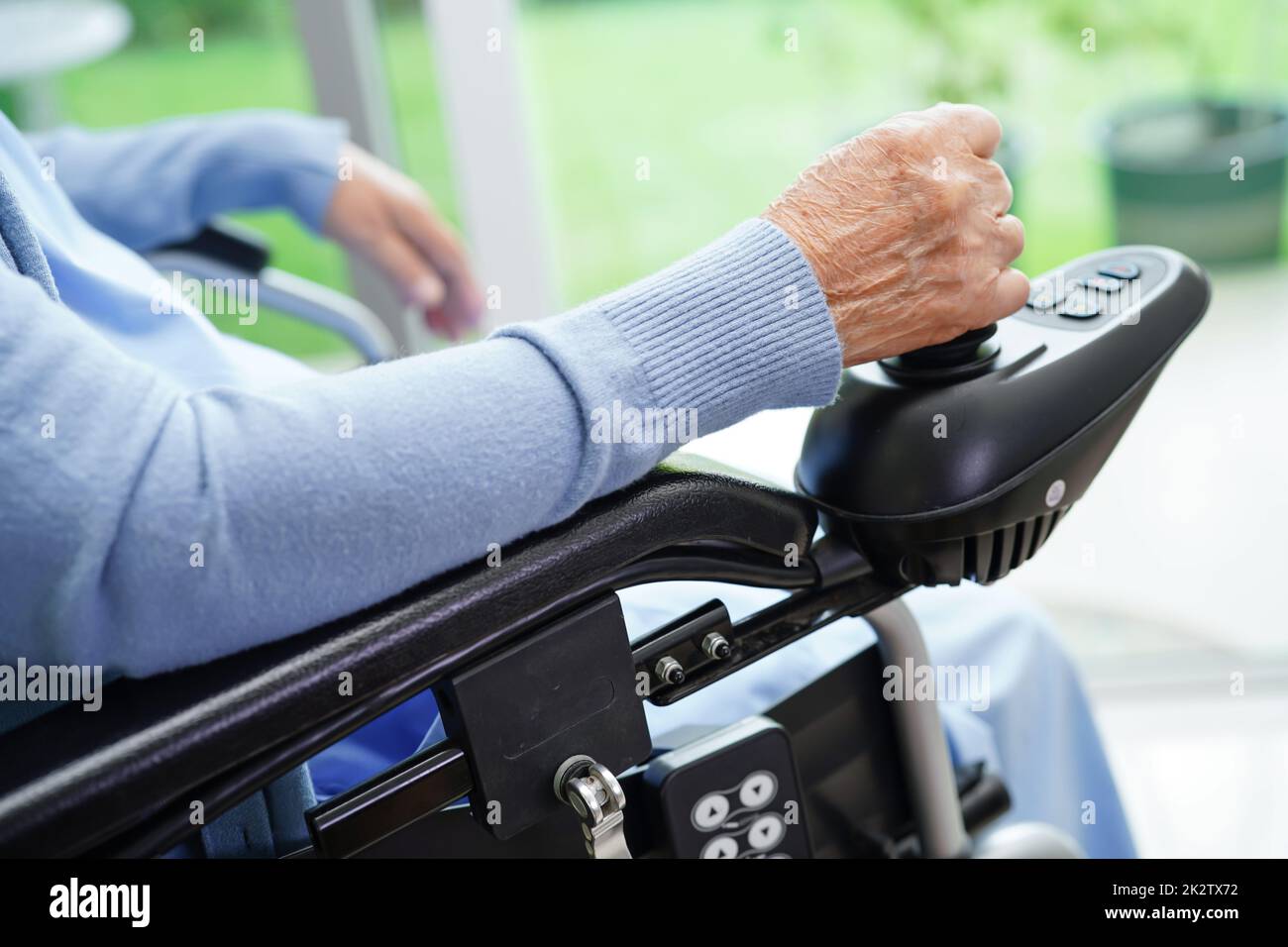 Asian elderly woman disability patient sitting on electric wheelchair